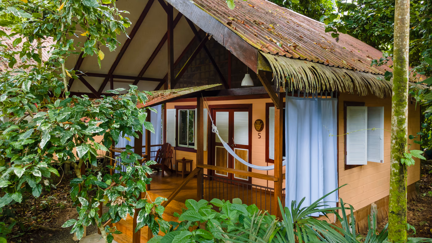 Family bungalow nestled among tropical trees at Namuwoki Lodge, Playa Chiquita