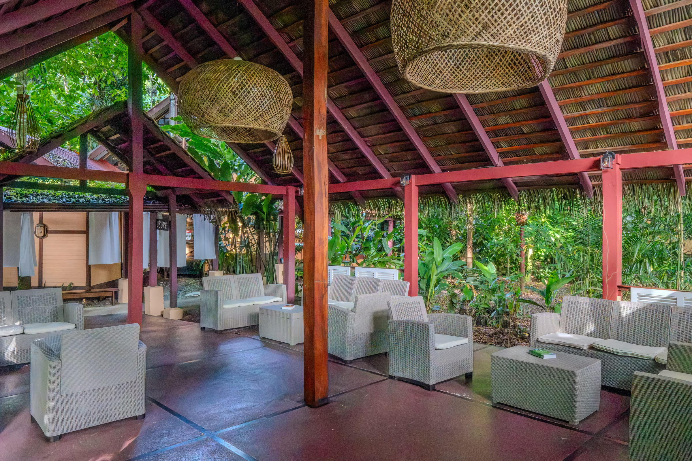Open-air pavilion with woven pendant lamps and wicker armchairs