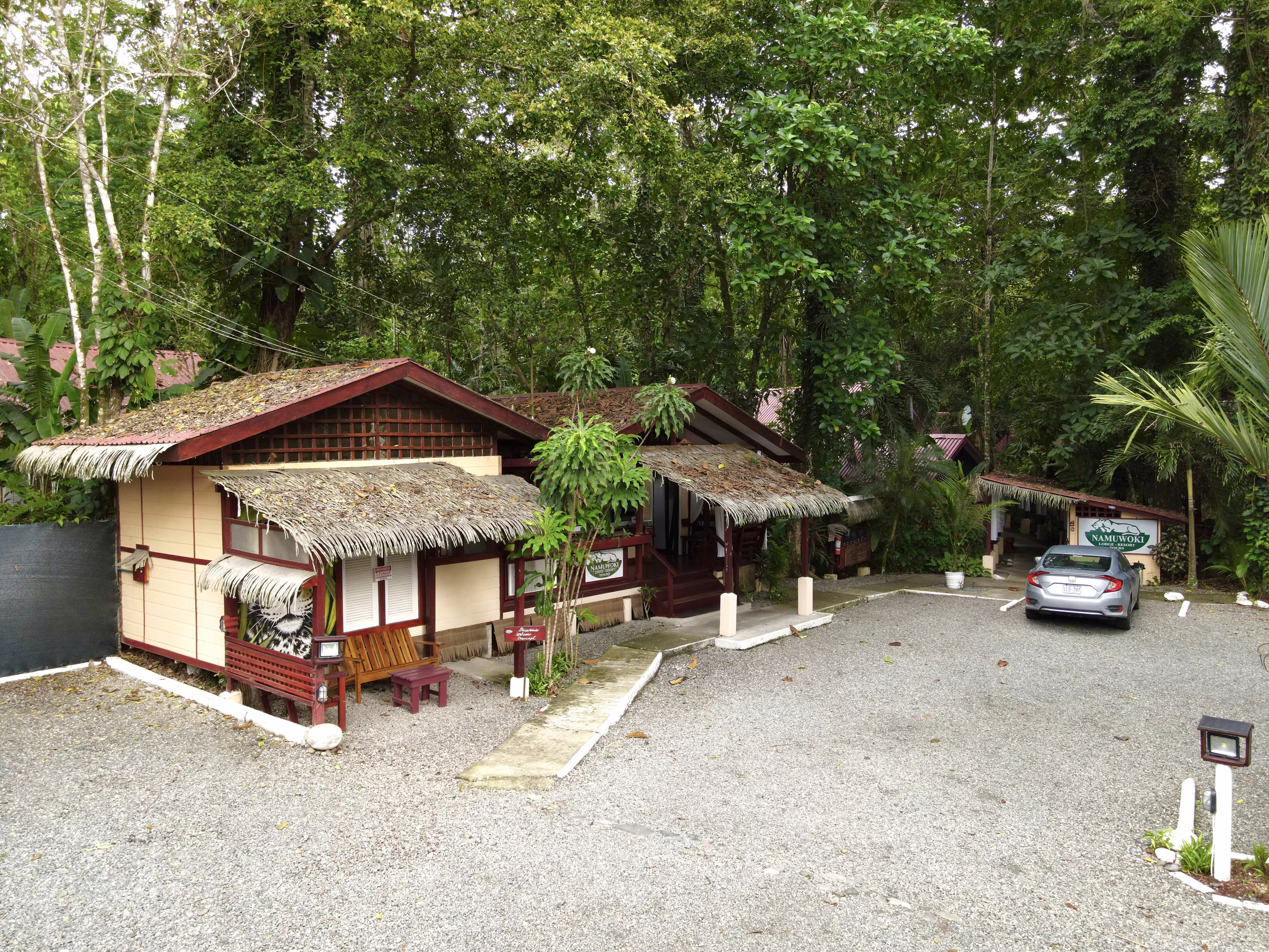 The thatched buildings of Namuwoki Lodge seen from the gravel drive on arrival