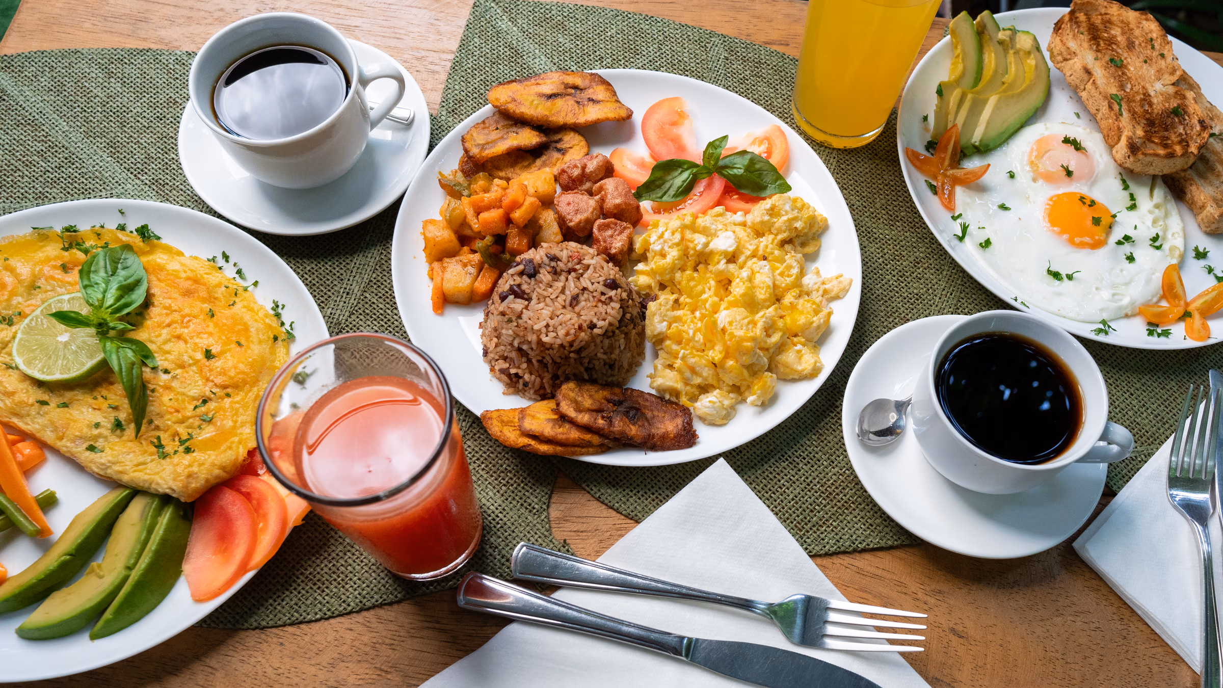 Traditional gallo pinto breakfast with plantain, scrambled eggs and fresh juice